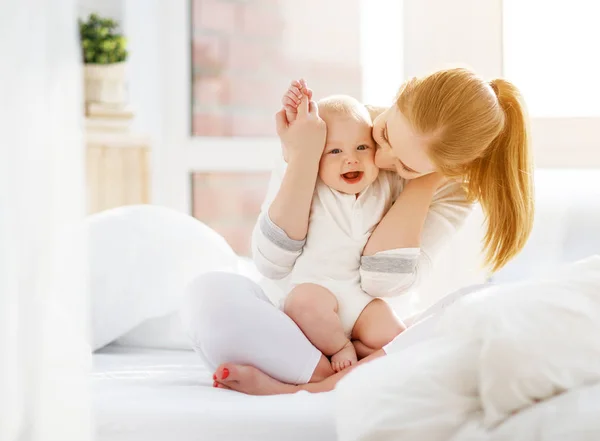 Gelukkige familie moeder en baby spelen, knuffelen in bed — Stockfoto