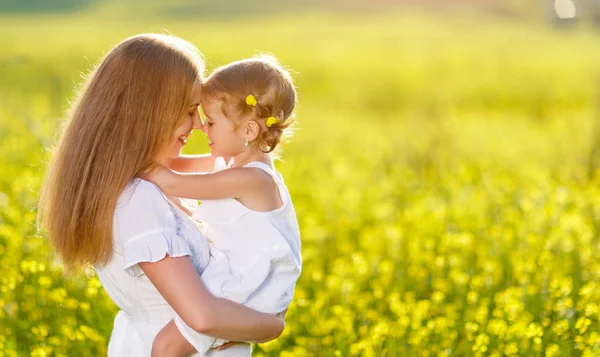 Lyckliga familjen mor och barn dotter omfamna på naturen i summan — Stockfoto