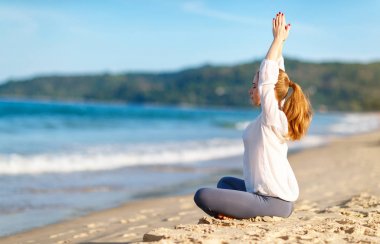 kadın yoga uygulamaları ve lotus pozisyonu Sahilde meditasyon