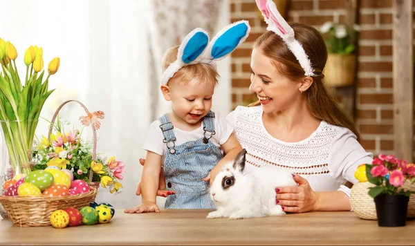 Happy easter! family mother and baby son playing with a rabbit a — Stock Photo, Image