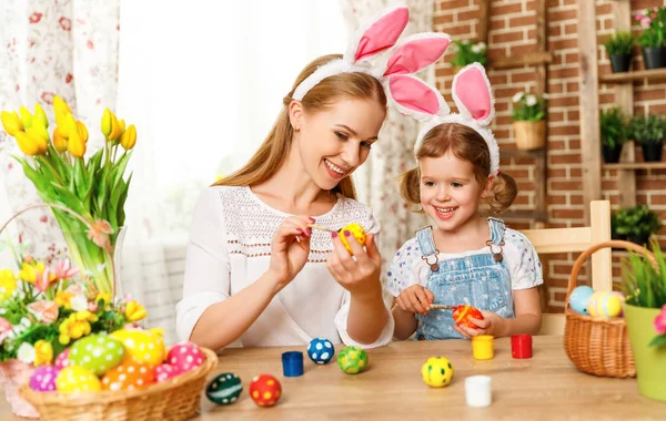 Happy easter! family mother and child daughter paint eggs for ho