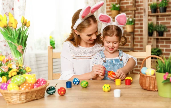 Happy easter! family mother and child daughter paint eggs for ho