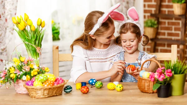 Happy easter! family mother and child daughter paint eggs for ho