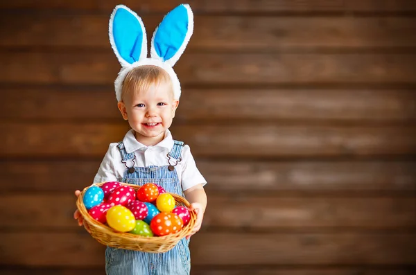 Lycklig pojke till påskharar kostym med korg med ägg — Stockfoto
