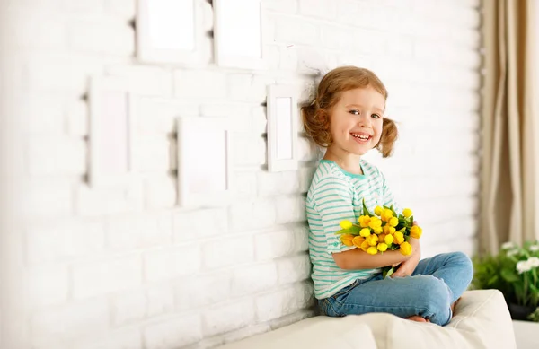 黄色チューリップ自宅で満足して笑っている子女の子 — ストック写真