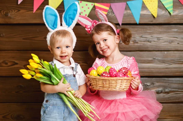 Gelukkige jonge geitjes jongen en meisje verkleed als Pasen konijnen met mandje van — Stockfoto