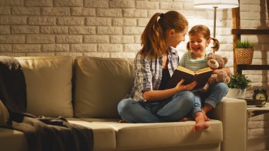 Yatak anne için gitmeden önce aile çocuk kızı kitap n için okur