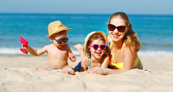 Feliz familia madre e hijos juegan y ríen en la playa — Foto de Stock
