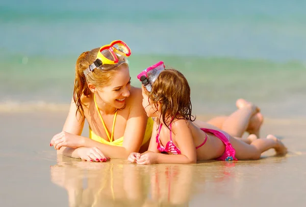 Happy family mother and chid daughter in masks on beach in summe — Stock Photo, Image