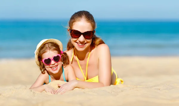 Gelukkige familie moeder en kind dochter op strand in de zomer — Stockfoto