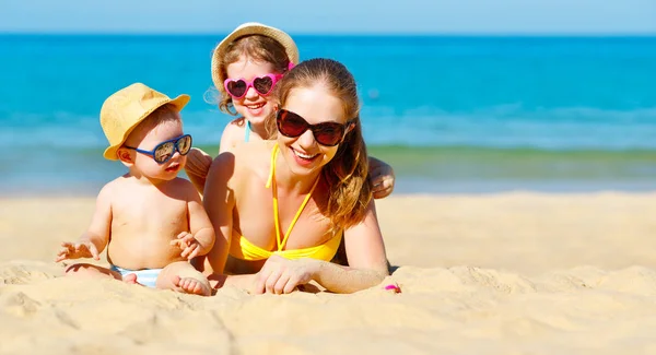 Gelukkige familie moeder en kinderen spelen en lachen op strand — Stockfoto