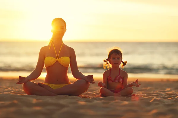 Família feliz mãe e criança fazendo ioga, meditar em lótus posi — Fotografia de Stock