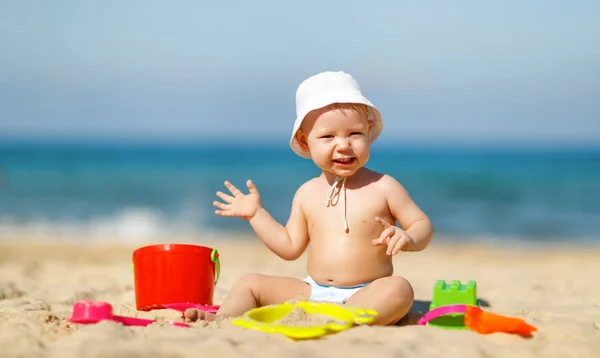 Baby chłopiec bawi się zabawkami i piasek na plaży — Zdjęcie stockowe