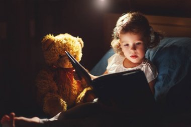 çocuk kız yatakta kitap okumak 