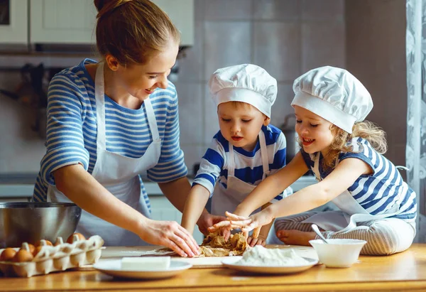 Família feliz na cozinha. mãe e filhos preparando massa, ba — Fotografia de Stock