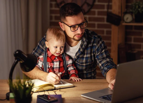 Otec a syn miminko práce doma na počítači ve tmě — Stock fotografie