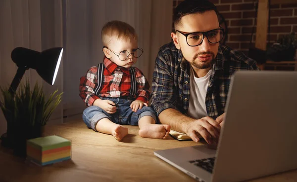 Father and son baby work at home at computer in dark — Stock Photo, Image