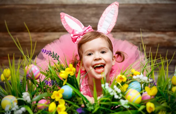 Fröhliches Kindermädchen im Osterhasenkostüm mit Eiern — Stockfoto