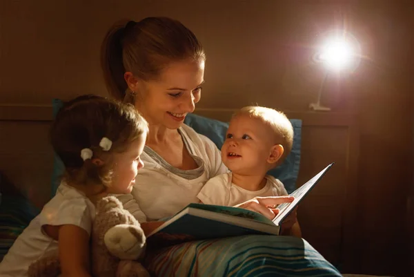 Anya felolvas gyermekek könyv az ágyban — Stock Fotó