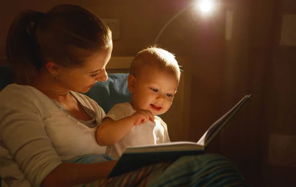母をベッドで赤ちゃんの本を読み取ります — ストック写真