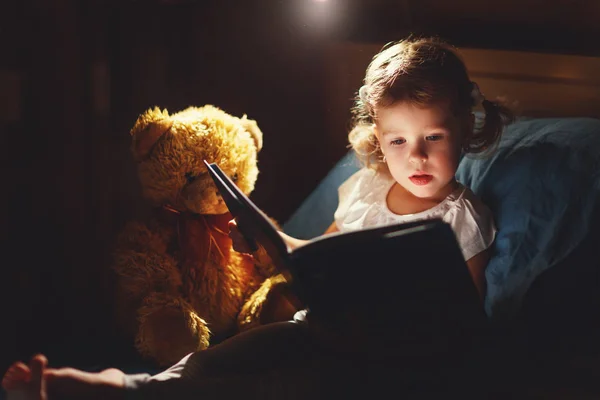 Дитяча дівчина читає книгу в ліжку — стокове фото
