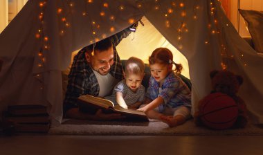 mutlu aile baba ve çocuk hom çadırına bir kitap okuma