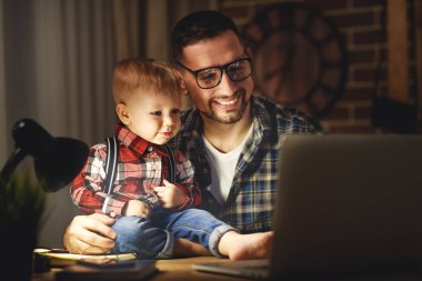 Baba ve oğul evde işyerinde bilgisayar karanlıkta bebeğim