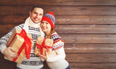 mutlu aile çift ahşap arka plan üzerinde Noel hediyeleri ile