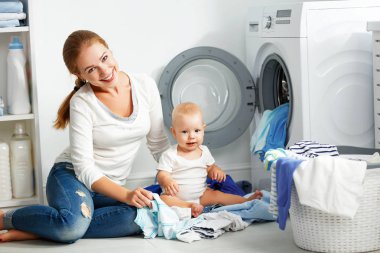 Bebek ile annesi ev hanımı Çamaşırhane kat giysi meşgul 