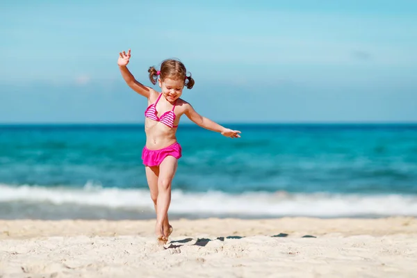 Joyeux enfant fille en bikini courir sur la plage en été mer — Photo