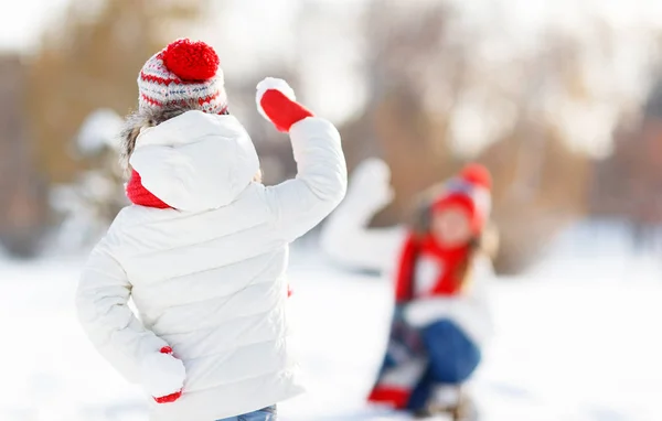 Lycklig familj mamma och barn leker snöbollar på vinterpromenad — Stockfoto