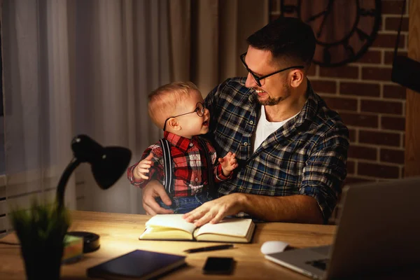 Vater und Sohn arbeiten im Dunkeln zu Hause am Computer — Stockfoto