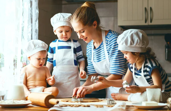 Счастливая семья на кухне. мать и дети готовят тесто, ба — стоковое фото