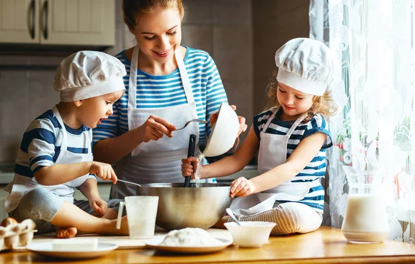 Família feliz na cozinha. mãe e filhos preparando massa, ba — Fotografia de Stock