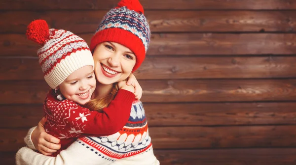 Boldog család anya és a gyermek lány ölelést fából készült háttér — Stock Fotó
