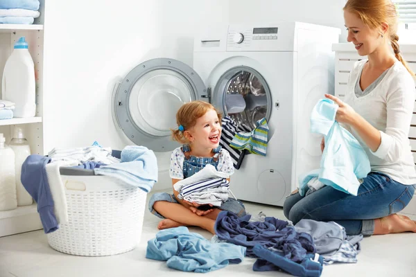 Mère de famille et enfant fille dans la buanderie près de machine à laver — Photo