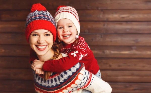 Felice famiglia madre e bambino ragazza abbracci a backgroun di legno — Foto Stock