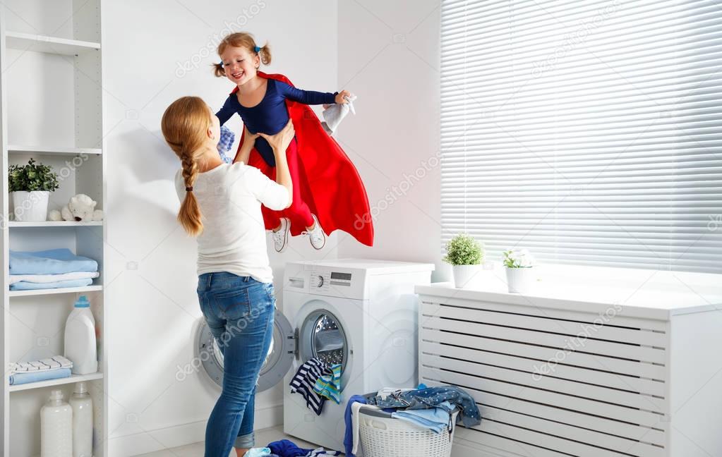 family mother and child girl little superhero helper in laundry 