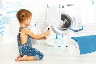 çocuk eğlence giyim ve oyuncak ayı Çamaşırhane roo yıkamak için mutlu küçük kız
