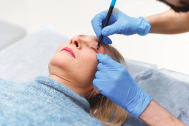 plastik cerrah cilt yaşlı bir patien yüzü sıkılaştırma için bir biçimlendirme yapar