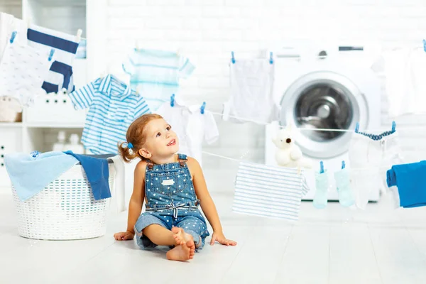 Child fun happy little girl to wash clothes in laundry room — Stock Photo, Image