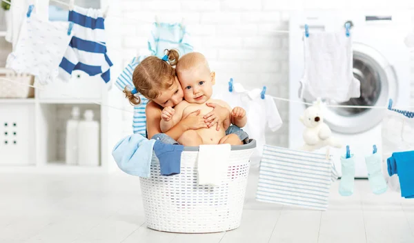 Pequeños ayudantes niños divertidos en la lavandería para lavar la ropa, jugando un — Foto de Stock