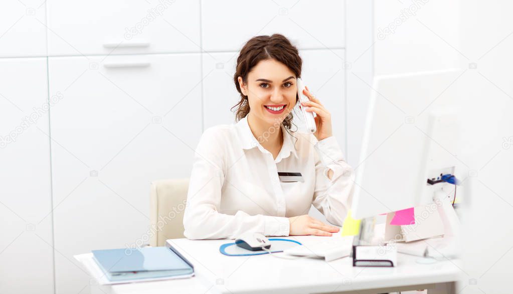 friendly young woman behind the reception desk administrato