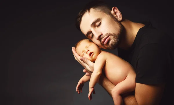 Yeni doğan bebeğin babasının ellerinde karanlıkta — Stok fotoğraf