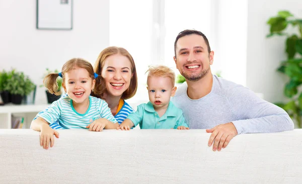 Glückliche Familie lacht und umarmt sich zu Hause auf dem Sofa — Stockfoto