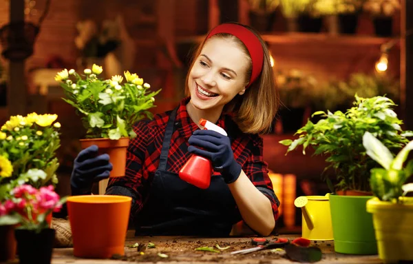 Donna felice trapianti giardiniere e fiori irrigazione — Foto Stock