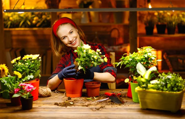 Donna felice trapianti giardiniere e fiori irrigazione — Foto Stock