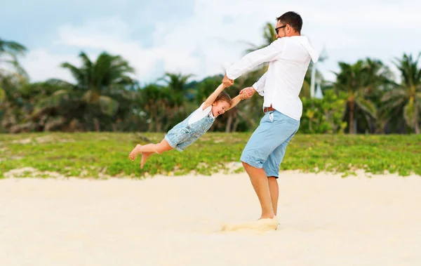 Feliz familia padre convierte hija en hija en la playa —  Fotos de Stock