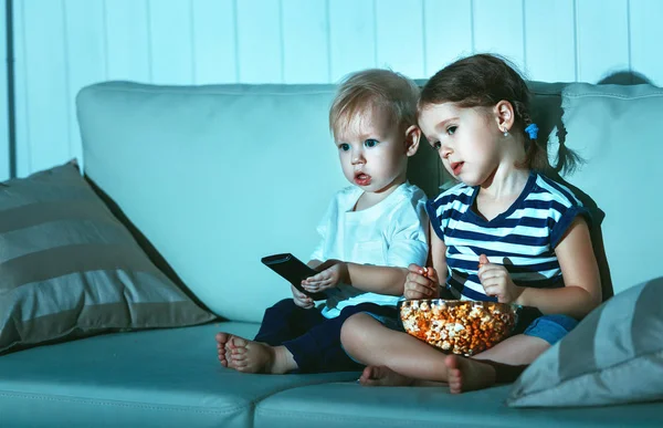 Дети брат и сестра смотрят телевизор вечером — стоковое фото