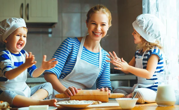 Happy family in kitchen. mother and children preparing dough, ba — Stock Photo, Image